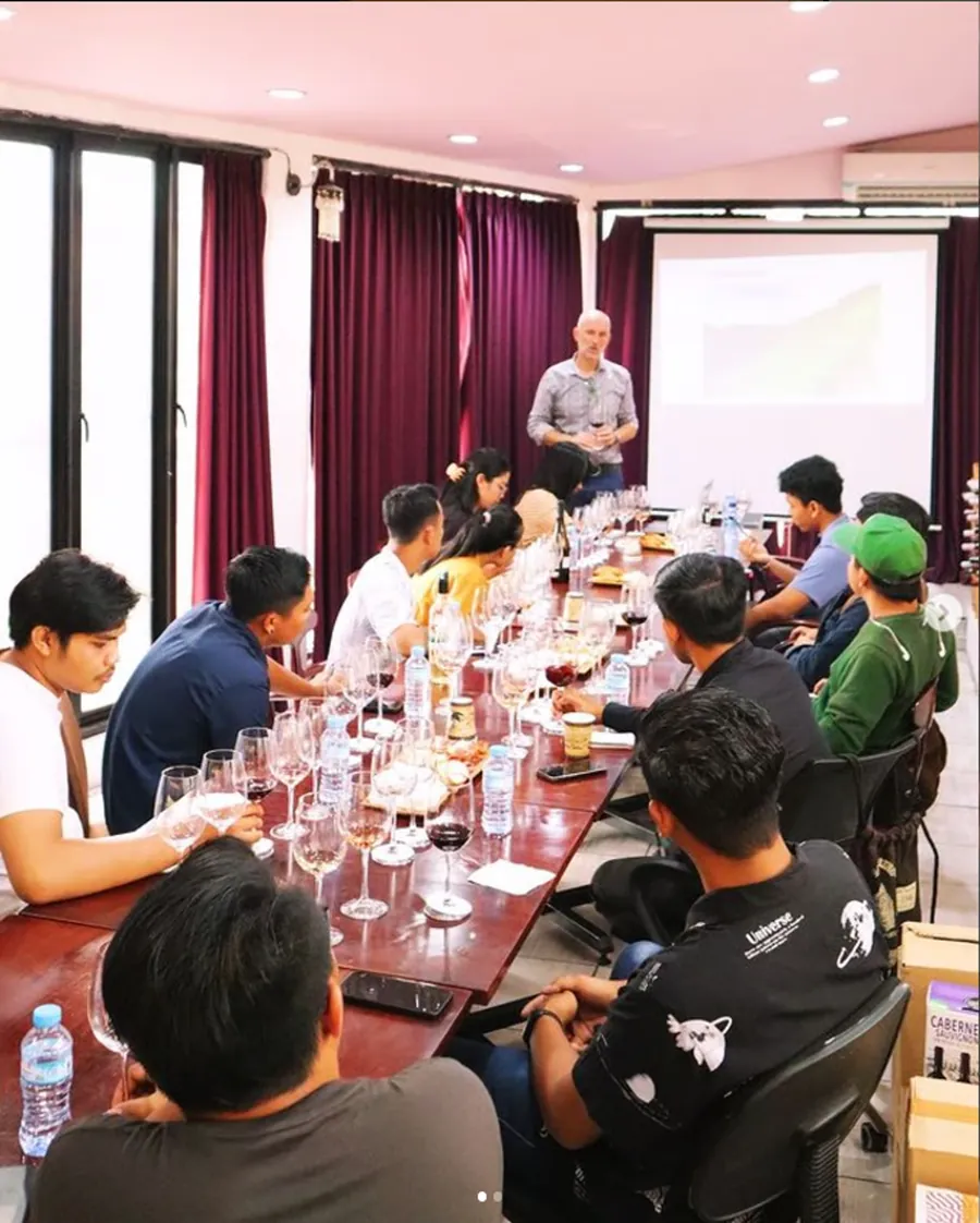 Edukator memandu kelas WSET di meja tasting panjang